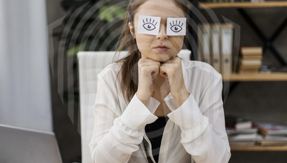 young-businesswoman-covering-her-eyes-with-drawn-eyes-paper